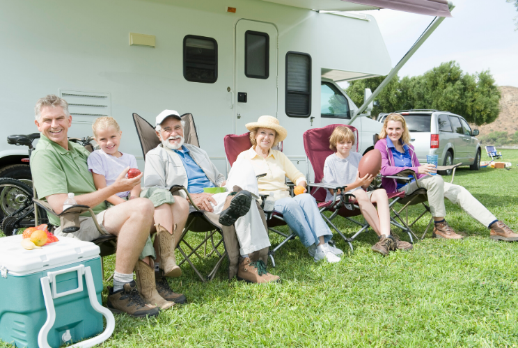Multiple people sitting outside of an RV