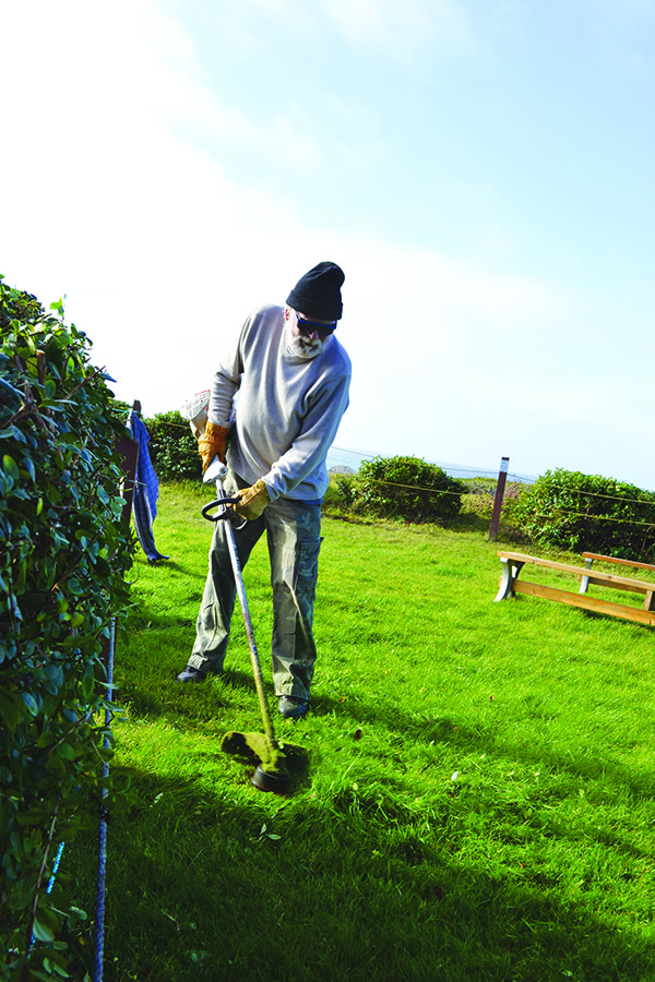 Workamper John using a trimmer at the campground he's working at