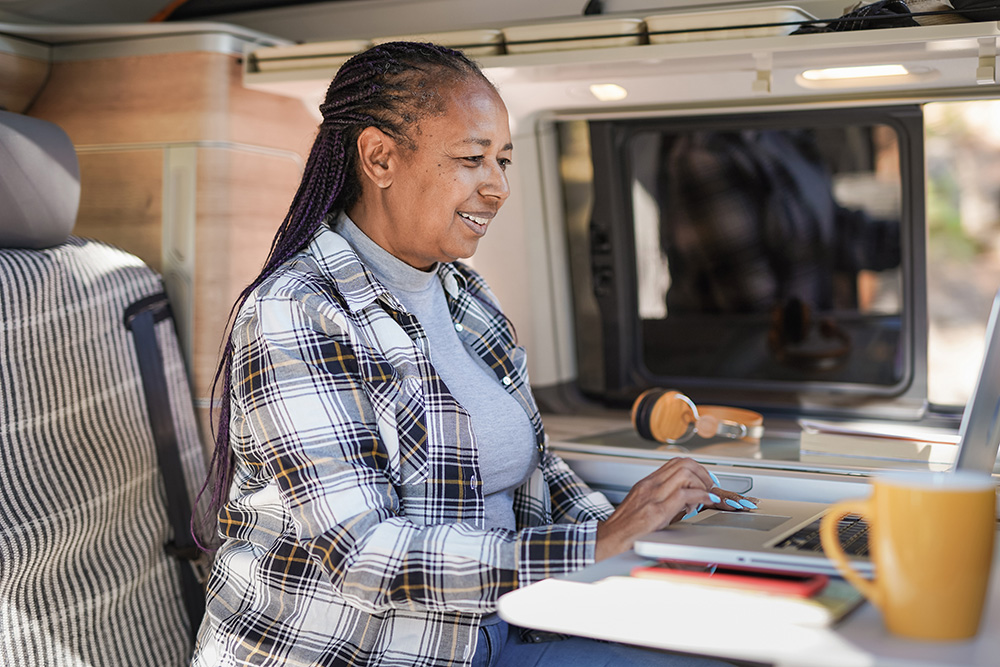 Woman looking at laptop at RV kitchen table