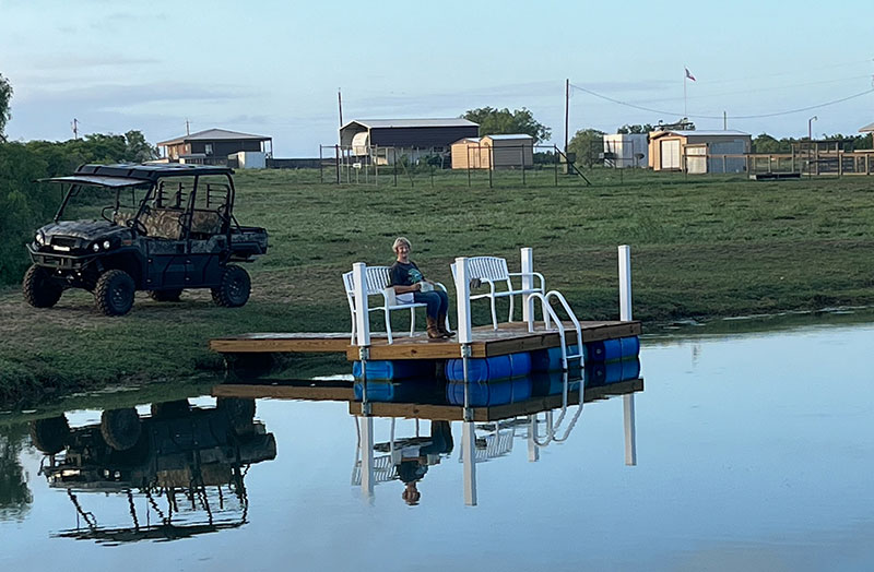 Photo of a person on a floating dock in a small pond located on a Texas ranch.