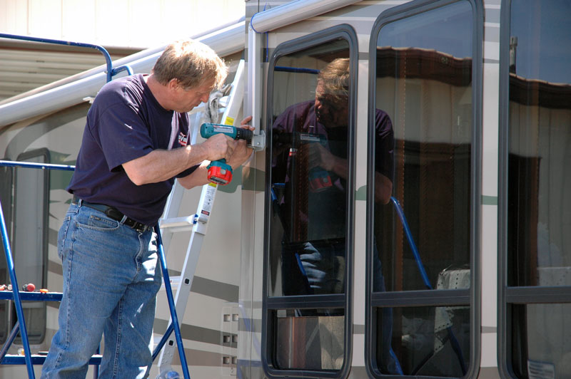 RV service tech installing awning